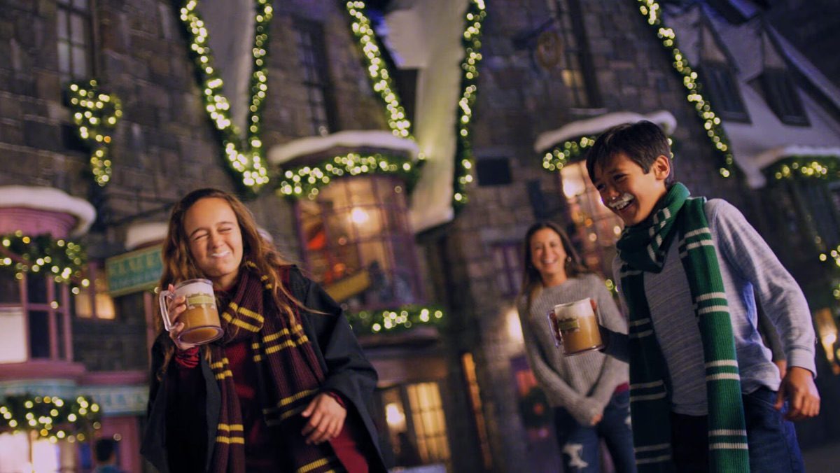 children smiling as christmas lights decorate universal studios wizarding world of harry potter